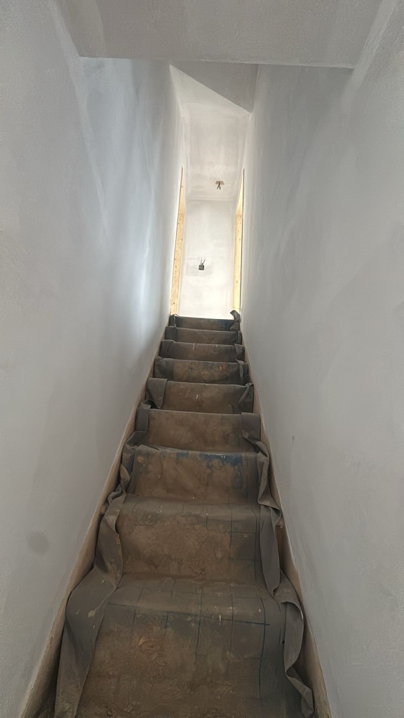 Staircase fully sheeted and protected while walls and ceilings are prepared for painting