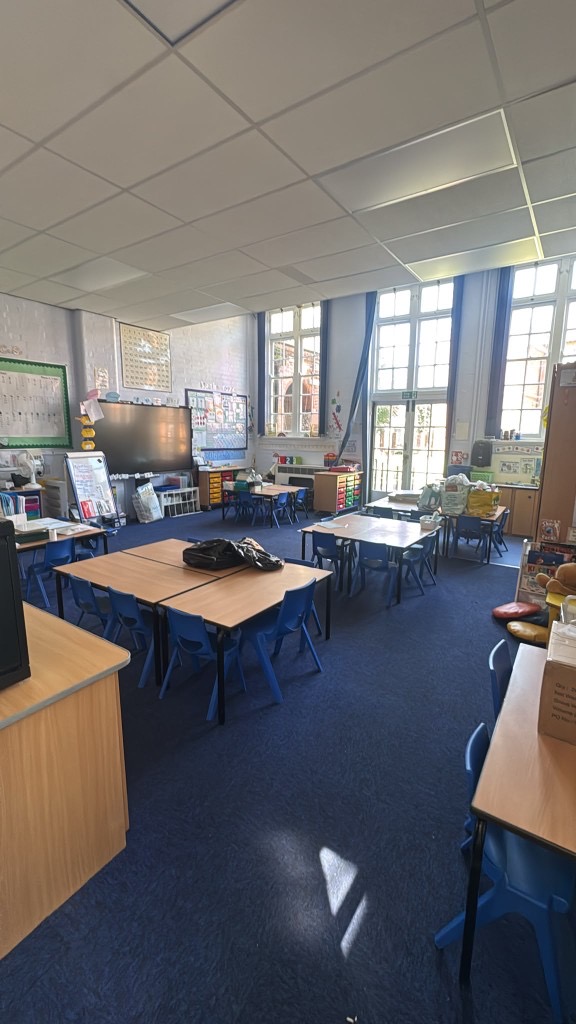 Bright classroom at Hazel Community Primary School with freshly painted white brick walls and large windows