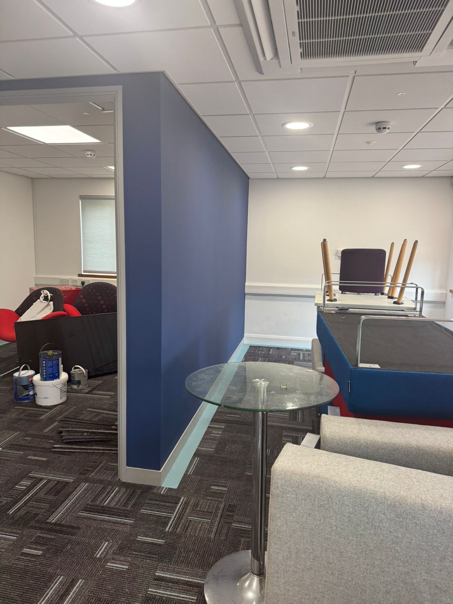 Office breakout area painted in deep navy with crisp white ceiling