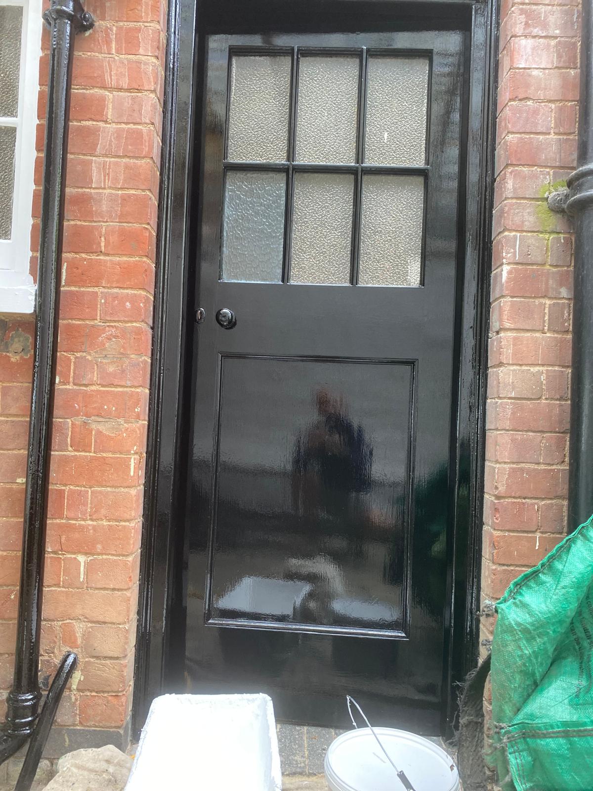 Front door in high-gloss black with crisp surrounding woodwork