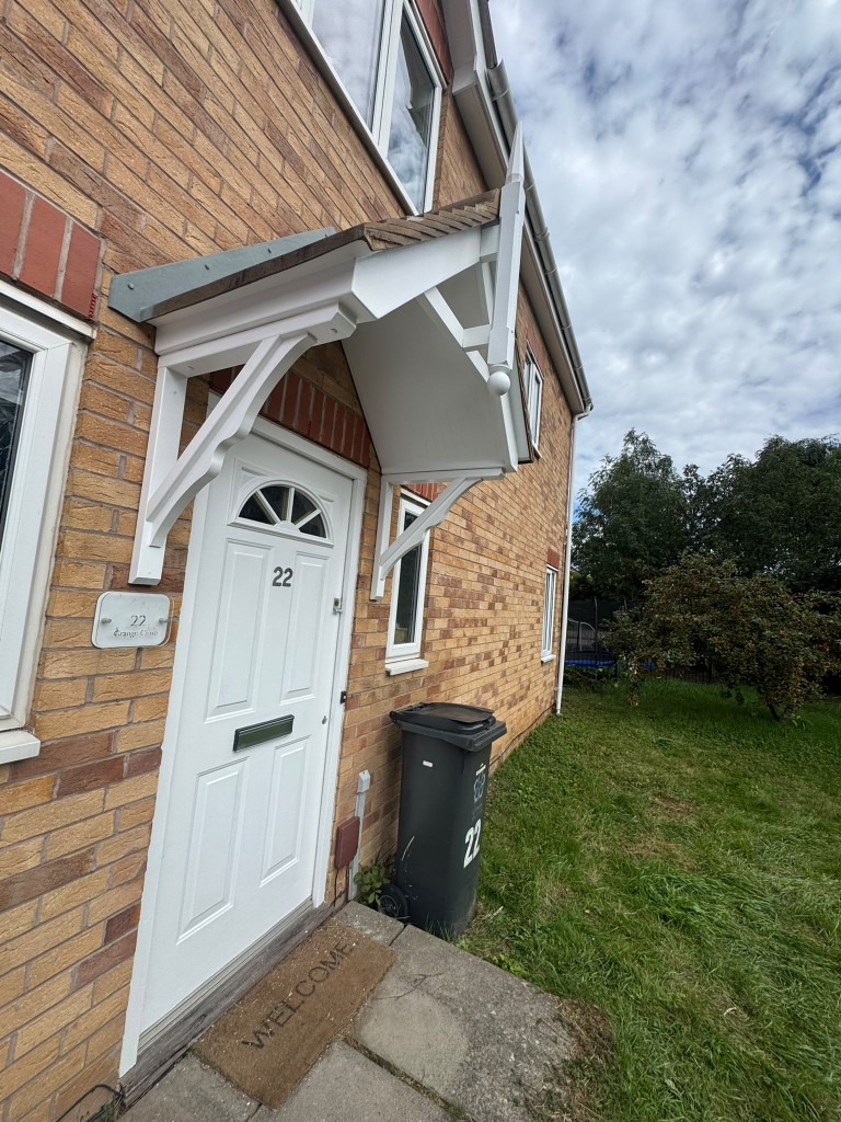 Freshly painted white porch canopy and front door on a brick house in Leicestershire