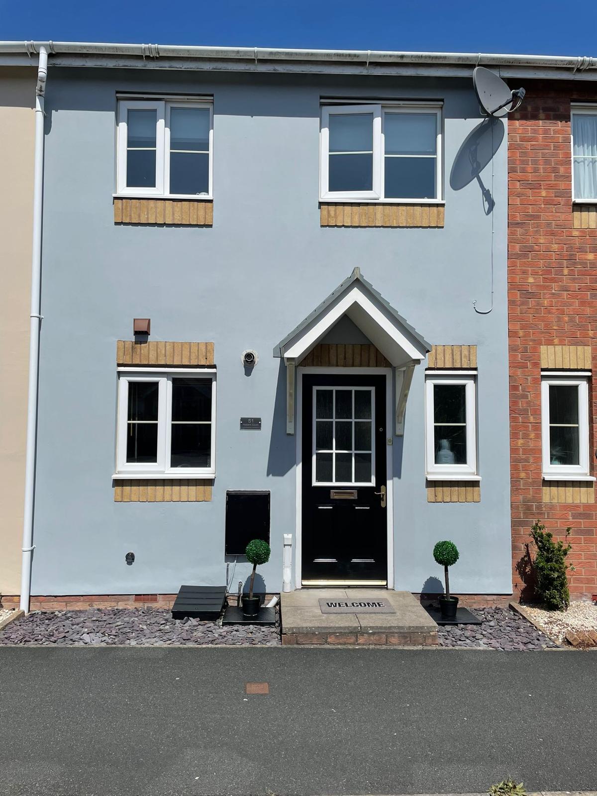 Rendered house exterior in grey-blue with fresh window frames