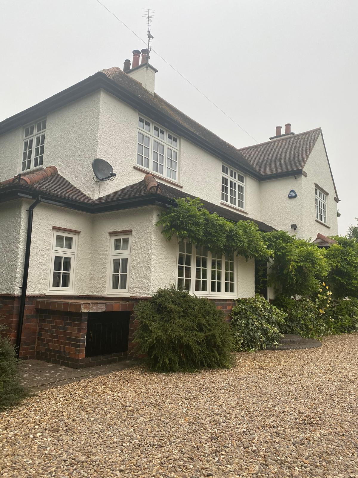 Period detached home with freshly painted white render and dark window frames