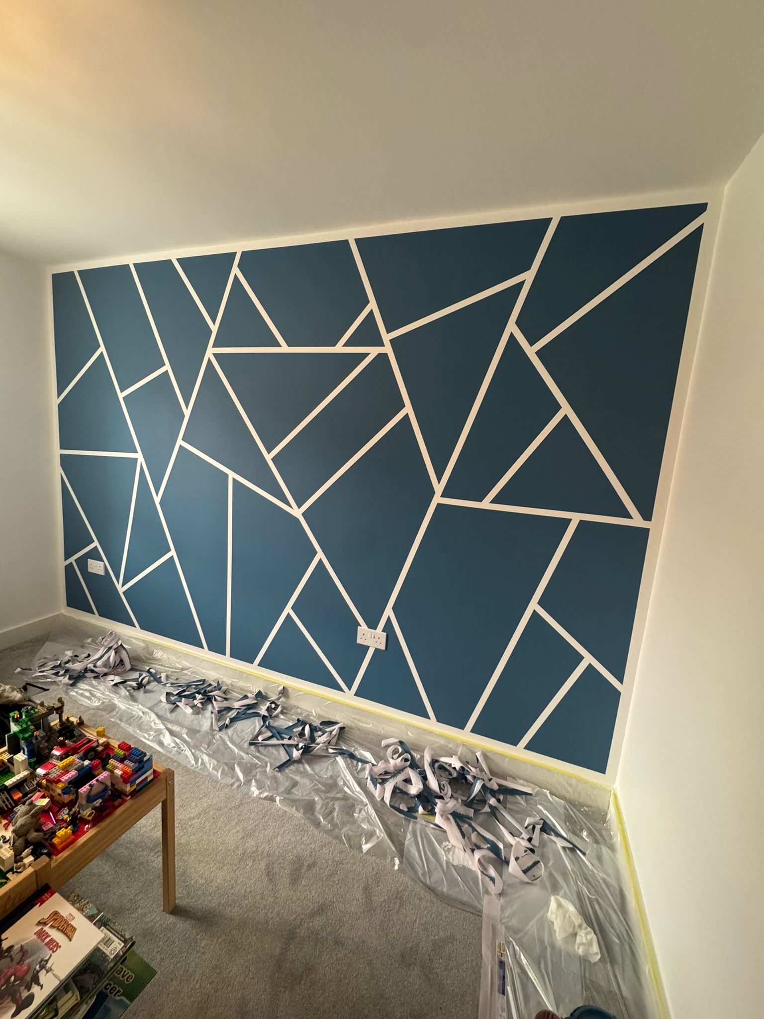 Living room with a bold geometric feature wall and fresh neutral paintwork