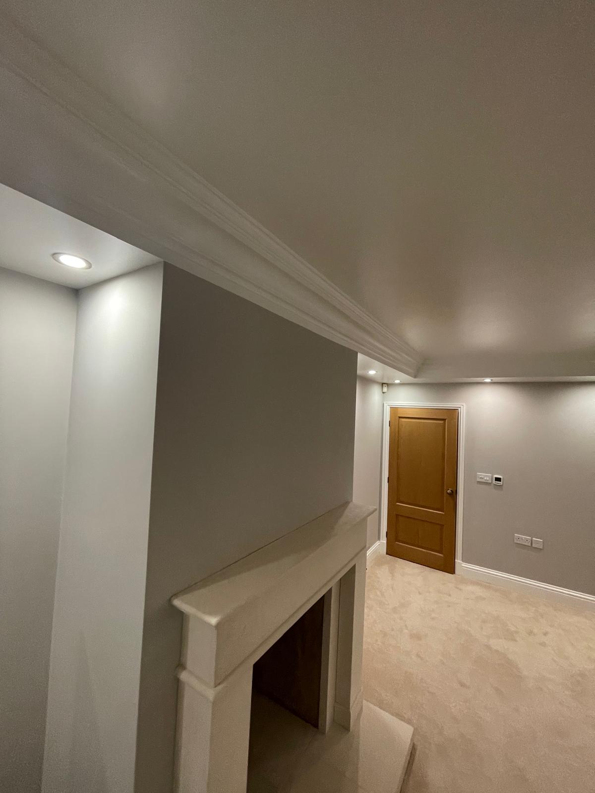 Living room with fireplace, cornice and freshly painted walls