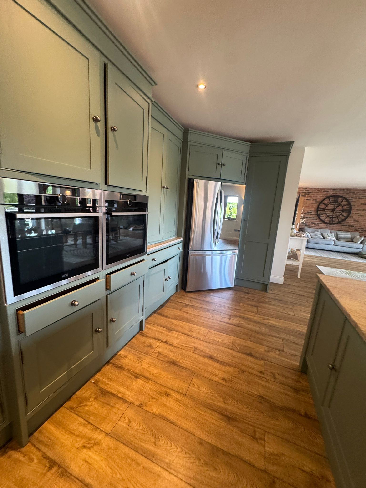 Sage green shaker kitchen with hand-painted cabinetry and crisp finishes