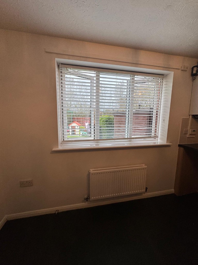 Freshly decorated bedroom with cream walls, white trim and blinds in a void property